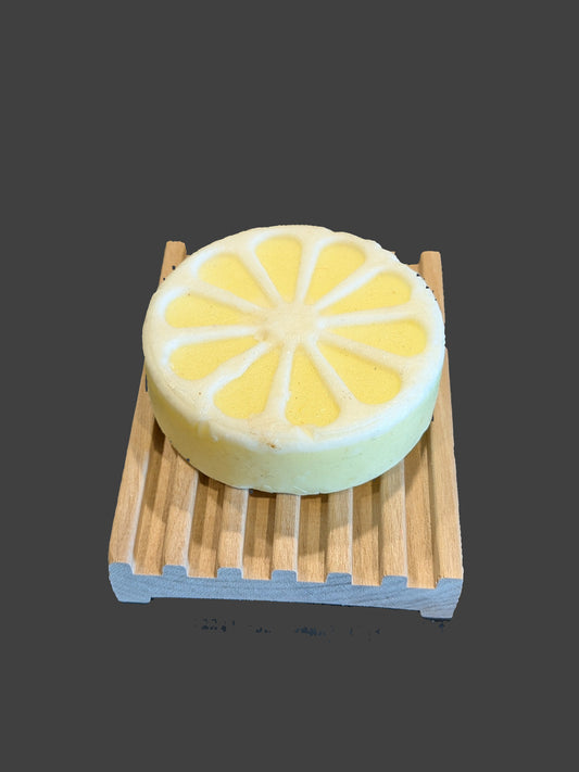 Lemon-shaped soap on a wooden stand over a black stovetop